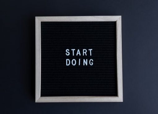 Black letter board with the motivational phrase 'Start Doing' in white text on a gray background.